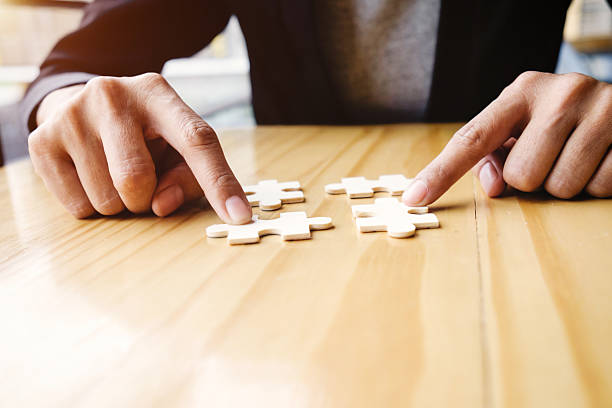 istock Female hands on a wooden office desk pick puzzle 579236538