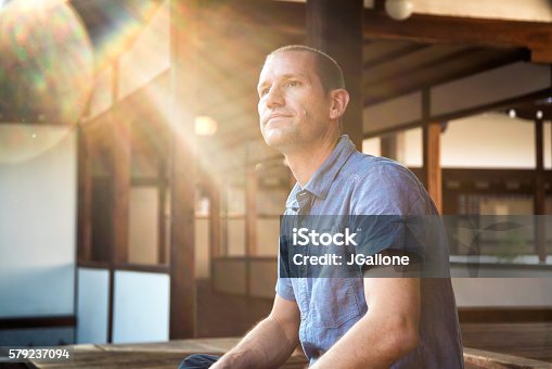 istock Man sat looking thoughtful at a Japanese Temple 579237094