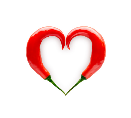Chili peppers forming a heart shape isolated on white background
