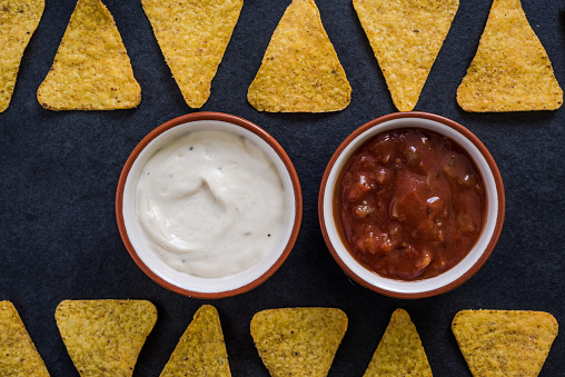 mexican nachos crisps with dip on dark slate