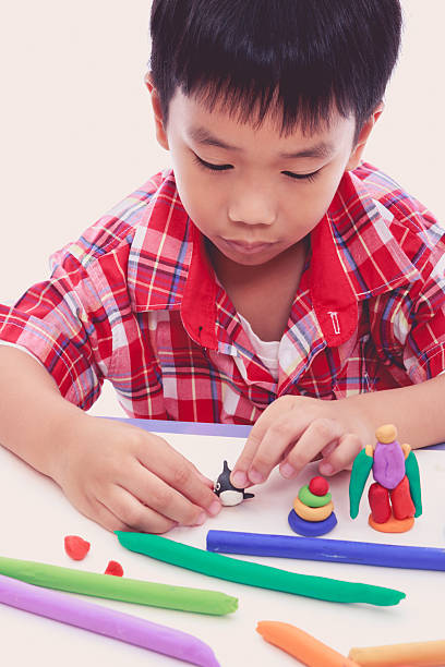 istock Child moulding whale modeling clay, on white background. 579238832