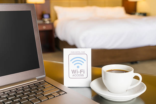 Hotel room with wifi access sign Hotel room with wifi access sign, laptop and cup of coffee wireless technology stock pictures, royalty-free photos & images
