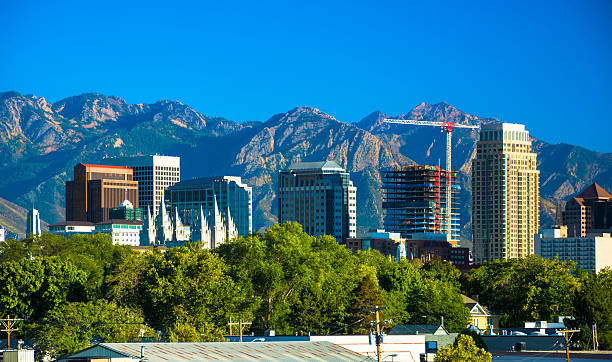 Salt Lake City Skyline and Mountains Downtown Salt Lake City skyline (including the Salt Lake Temple) with the Wasatch Range mountains in the background. salt lake city mormon temple utah photos stock pictures, royalty-free photos & images