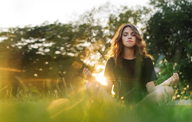 istock The girl meditates on the grass at sunset 579247968