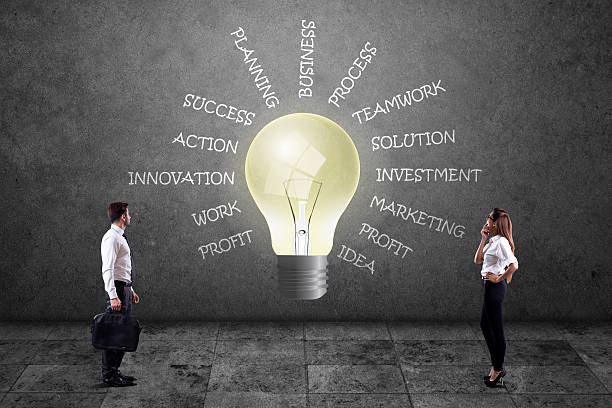 istock Business people looking at lightbulb with business words 579250370