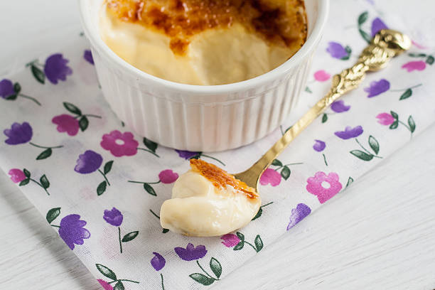 ramekin con creme brulee e cucchiaio al centro - brule foto e immagini stock