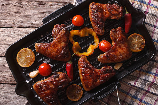 istock BBQ chicken wings with vegetables in a pan close-up. horizontal 579255252