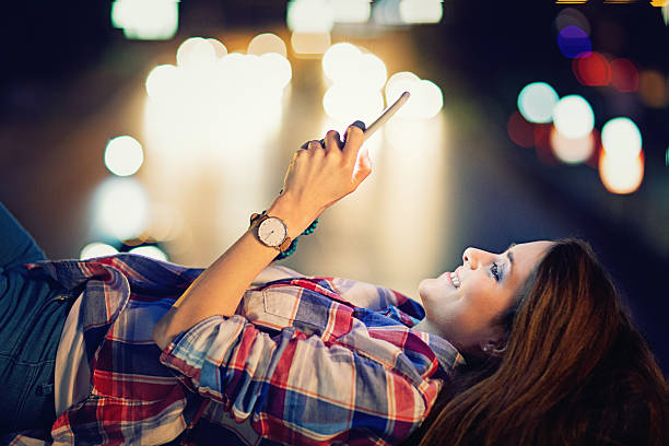 istock Young girl is lying and texting on the bridge 579255486
