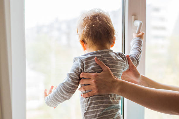 istock Cute baby boy looks in the window 579256052