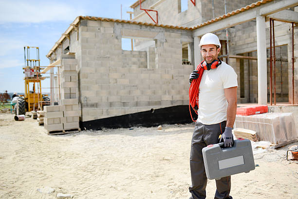 portrait of handsome construction worker on building industry construction site - protective workwear bricklayer manual worker construction imagens e fotografias de stock