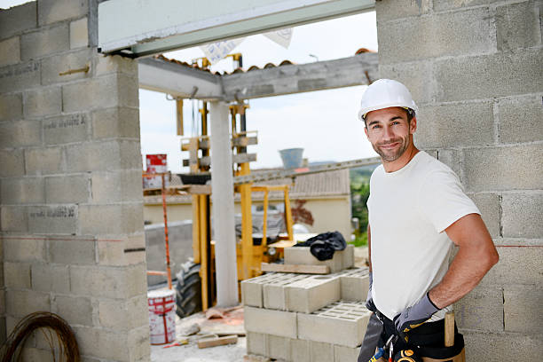 portrait of handsome construction worker on building industry construction site - protective workwear bricklayer manual worker construction imagens e fotografias de stock