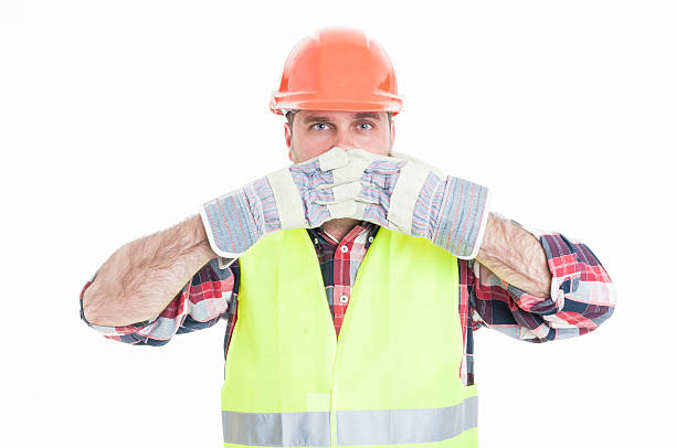 istock Constructor in safety equipment covering his mouth 579262414