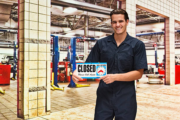 istock Smiling mechanic holding closed sign 579262908