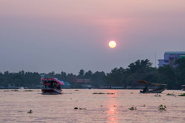 istock the sun set with boat and river in Thailand 579400144