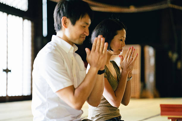 istock Japanese couple praying in a buddhist temple 579400718