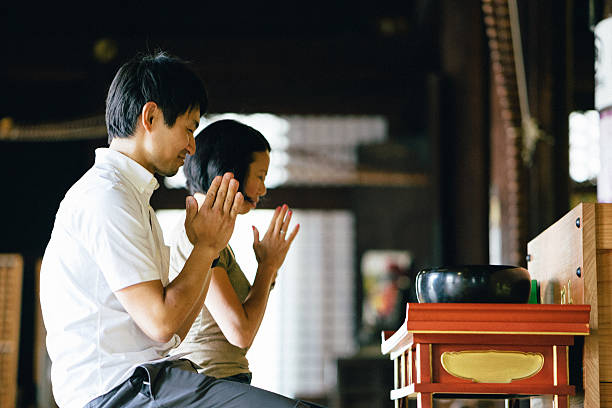 istock Japanese couple praying in a buddhist temple 579400998