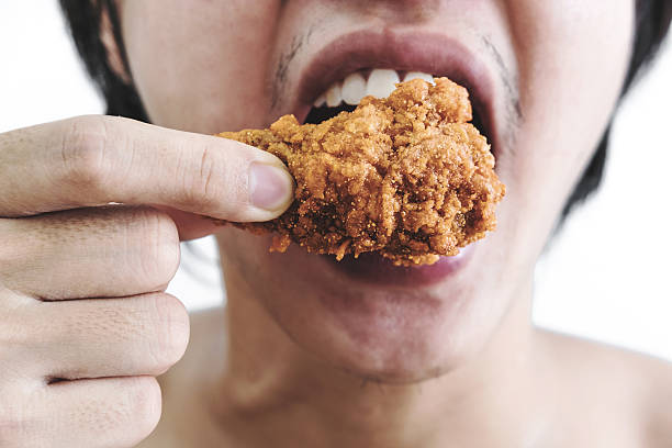 istock Asian guy biting fried chicken, vintage tone 579401036