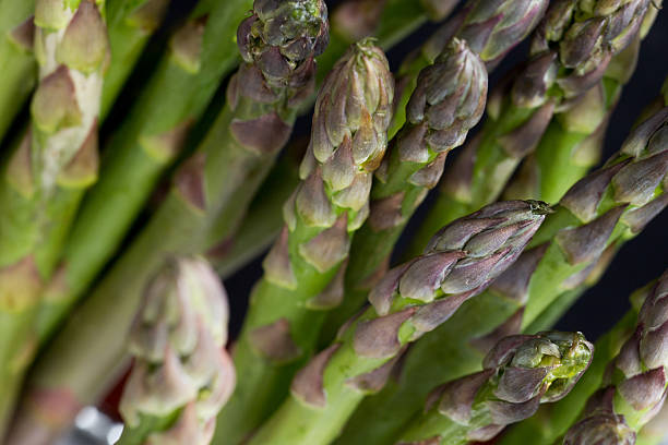 istock Bunch of asparagus on table. Uncooked pile raw vegetarian cuisine 579401176