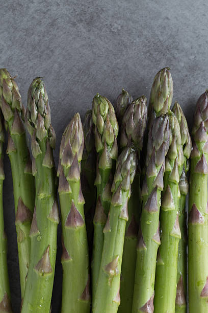 istock Bunch of asparagus on table. Uncooked pile raw vegetarian cuisine 579401340