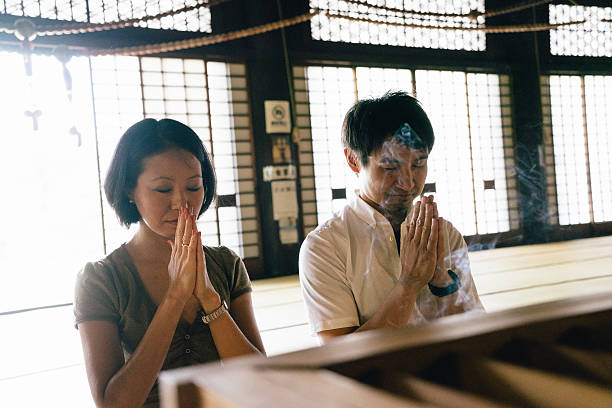 istock Japanese couple praying in a buddhist temple 579401344