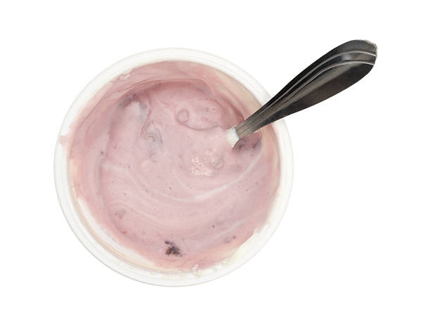 istock Container of stirred black cherry Greek yogurt with spoon 579401518