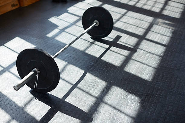istock High angle view of black barbell on gym floor 579403256