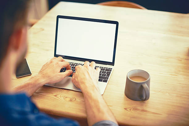 istock Cropped image of male blogger using laptop by coffee cup 579405230