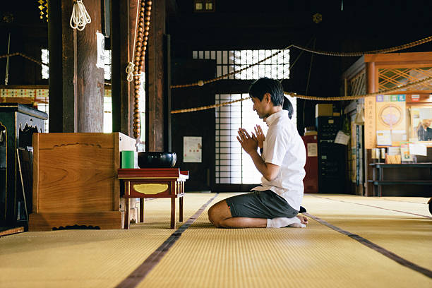 istock Japanese couple praying in a buddhist temple 579405488