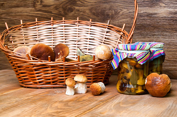 istock Fresh mushrooms in basket and jars on wooden table 579405754