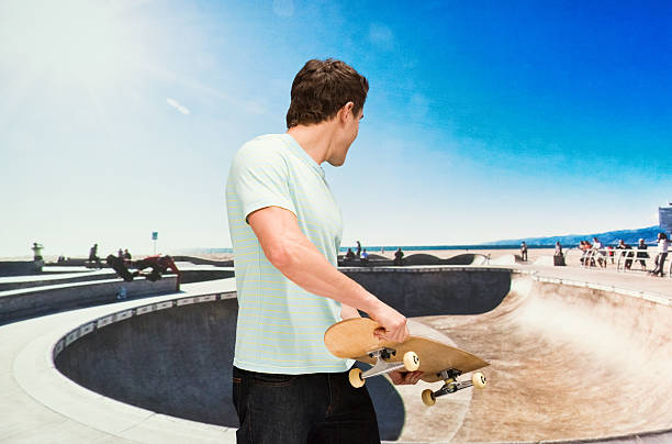 istock Man holding skateboard outdoors 579406444