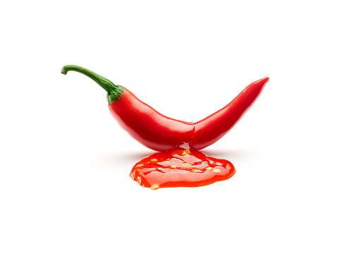 Chili sauce leaking from a chili pepper cut isolated on white background
