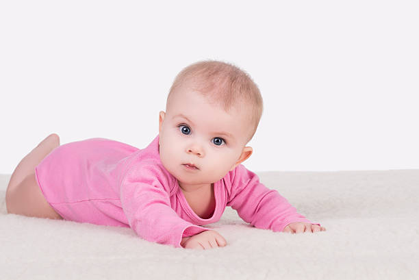 baby girl lying on blanket and try crawling