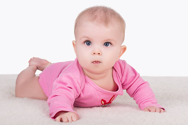 istock baby girl lying on blanket and try crawling 579407264