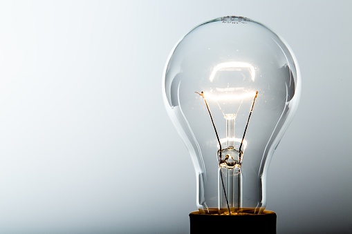 Standard Incandescent Light Bulb on Grey Background