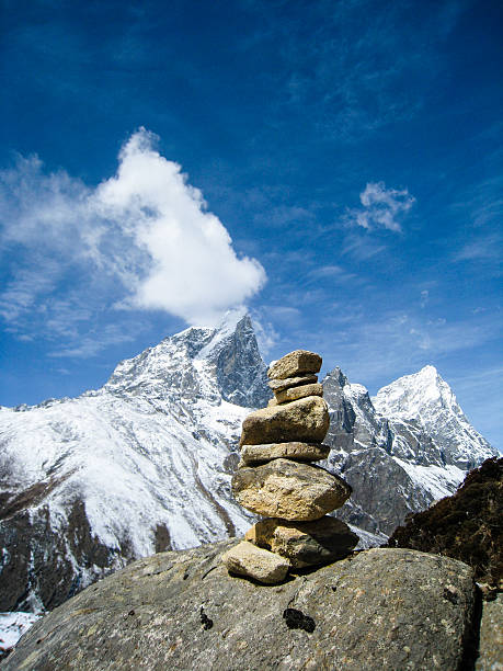 istock Stone cairn with snow  mountain in himalayas 579408504