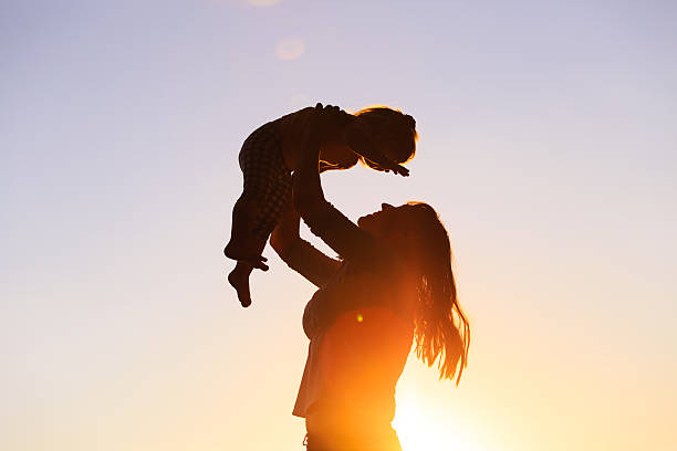 istock mother and little daughter play at sunset 579408516