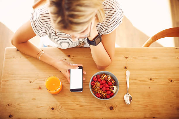 Overhead of hipster with smart phone and breakfast at table
