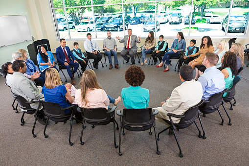Diverse group of people sitting in a circle having a discussion.