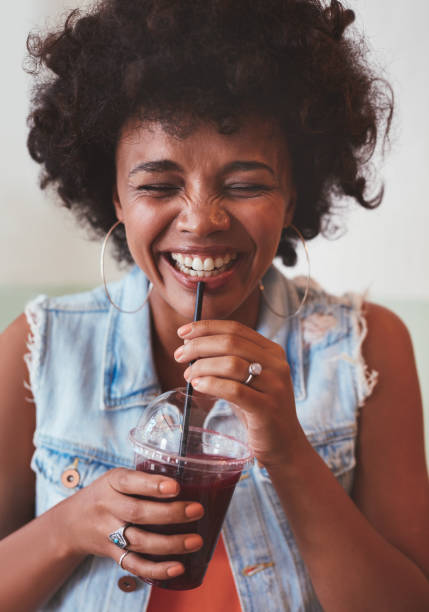 istock Happy young woman enjoying fresh fruit juice 579409476