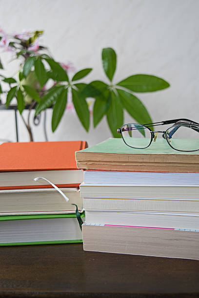 istock Stack of books with glasses on wooden desk 579409934