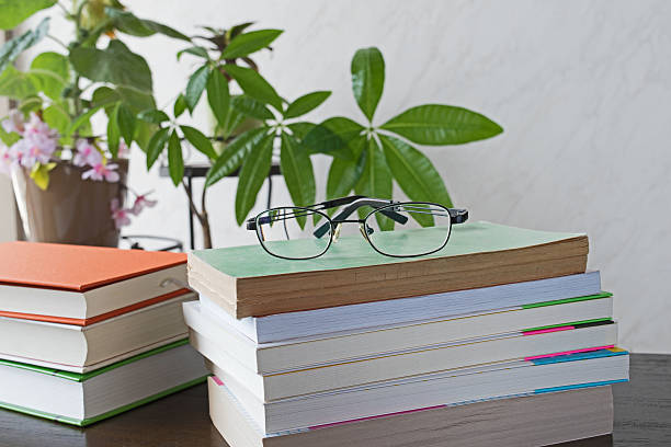 istock Stack of books with glasses on wooden desk 579409950