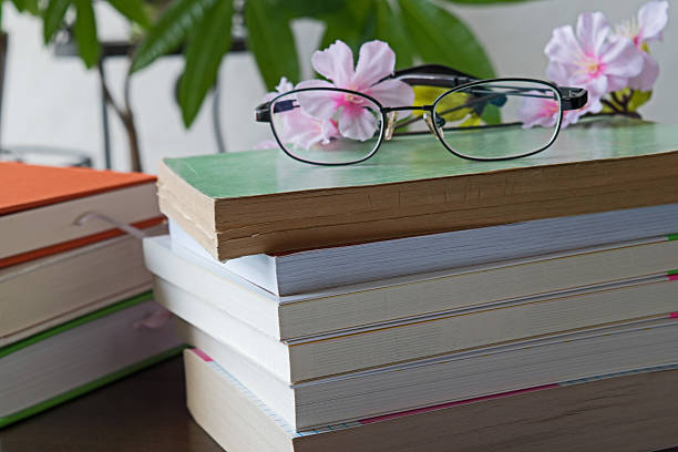 istock Stack of books with glasses on wooden desk 579409978