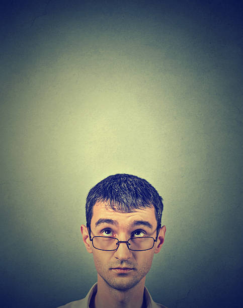 istock Closeup portrait pensive young man looking up 579410002