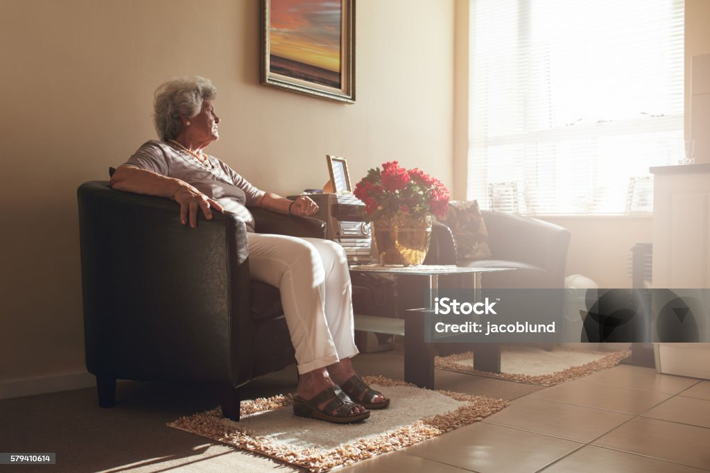 Seniorin sitzt allein auf einem Stuhl zu Hause - Lizenzfrei Alter Erwachsener Stock-Foto