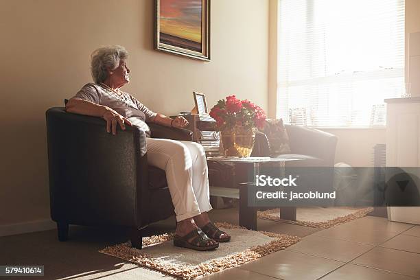 Seniorin Sitzt Allein Auf Einem Stuhl Zu Hause Stockfoto und mehr Bilder von Alter Erwachsener - Alter Erwachsener, Seniorinnen, Einsamkeit