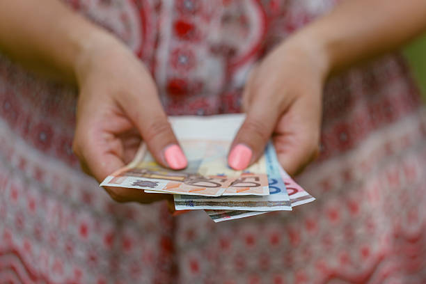 istock woman holding Euro bill in her hands 579410828