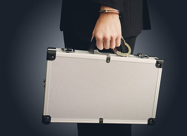 istock Hand in handcuffs holding money suitcase 579412852