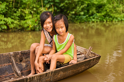 Two young girls on the boat in the Mekong river delta, Vietnam.