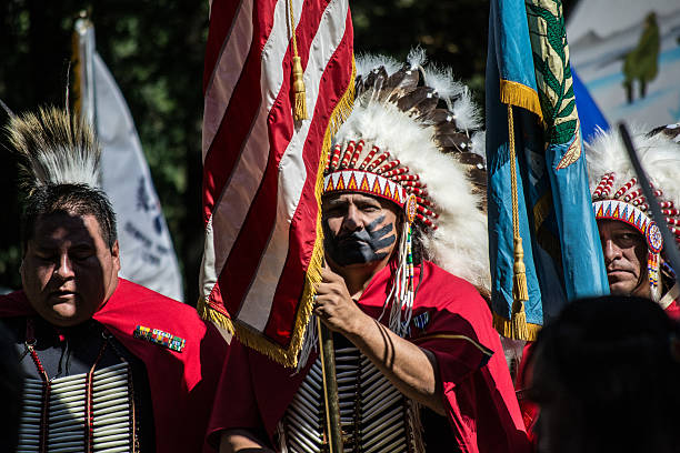 Veterans holding flags during color guard at Kiowa Blackleggings Pow-wow. Anadarko, Oklahoma, U.S.A.  - October 11, 2015: Veterans holding flags during color guard at Kiowa Blackleggings Pow-wow. kiowa stock pictures, royalty-free photos & images