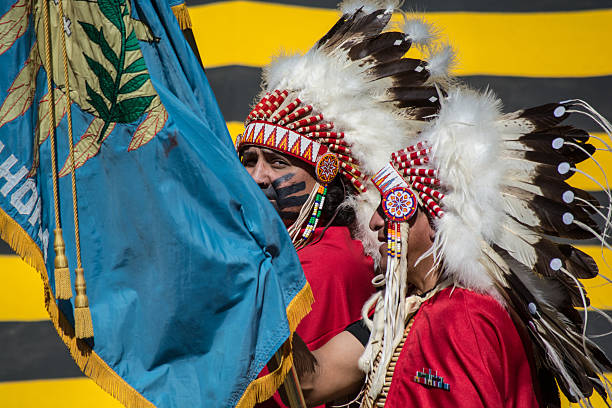 Kiowa men with Oklahoma flag during color guard at Pow-wow. Anadarko, Oklahoma, U.S.A. - October 11, 2015: Kiowa men with Oklahoma flag during color guard at Kiowa Blackleggings Pow-wow. kiowa stock pictures, royalty-free photos & images